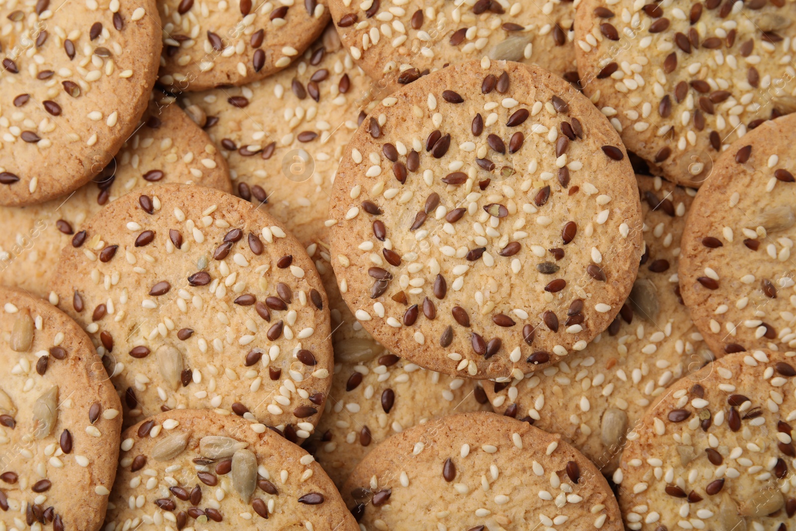 Photo of Cereal crackers with flax and sesame seeds as background, top view