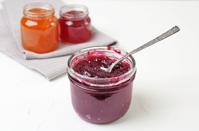 Photo of Jar with sweet jam on white table