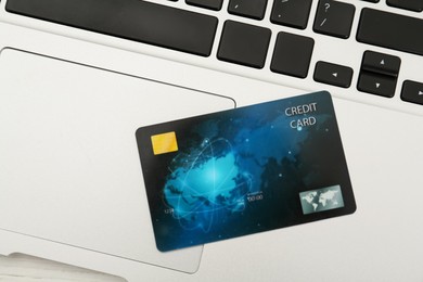 Photo of Online payment concept. Bank card on laptop keyboard, top view