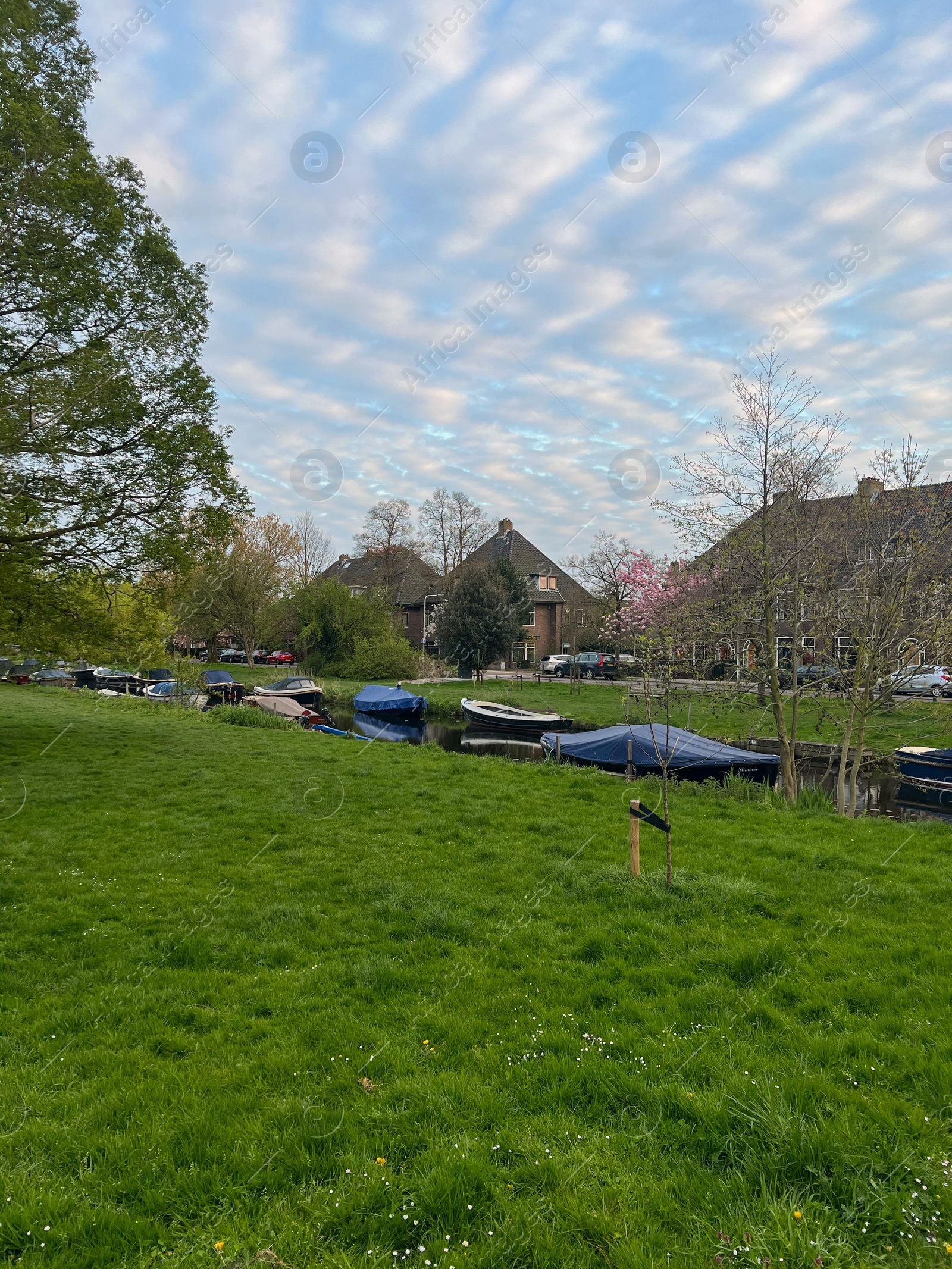 Photo of Canal with moored boats outdoors on spring day