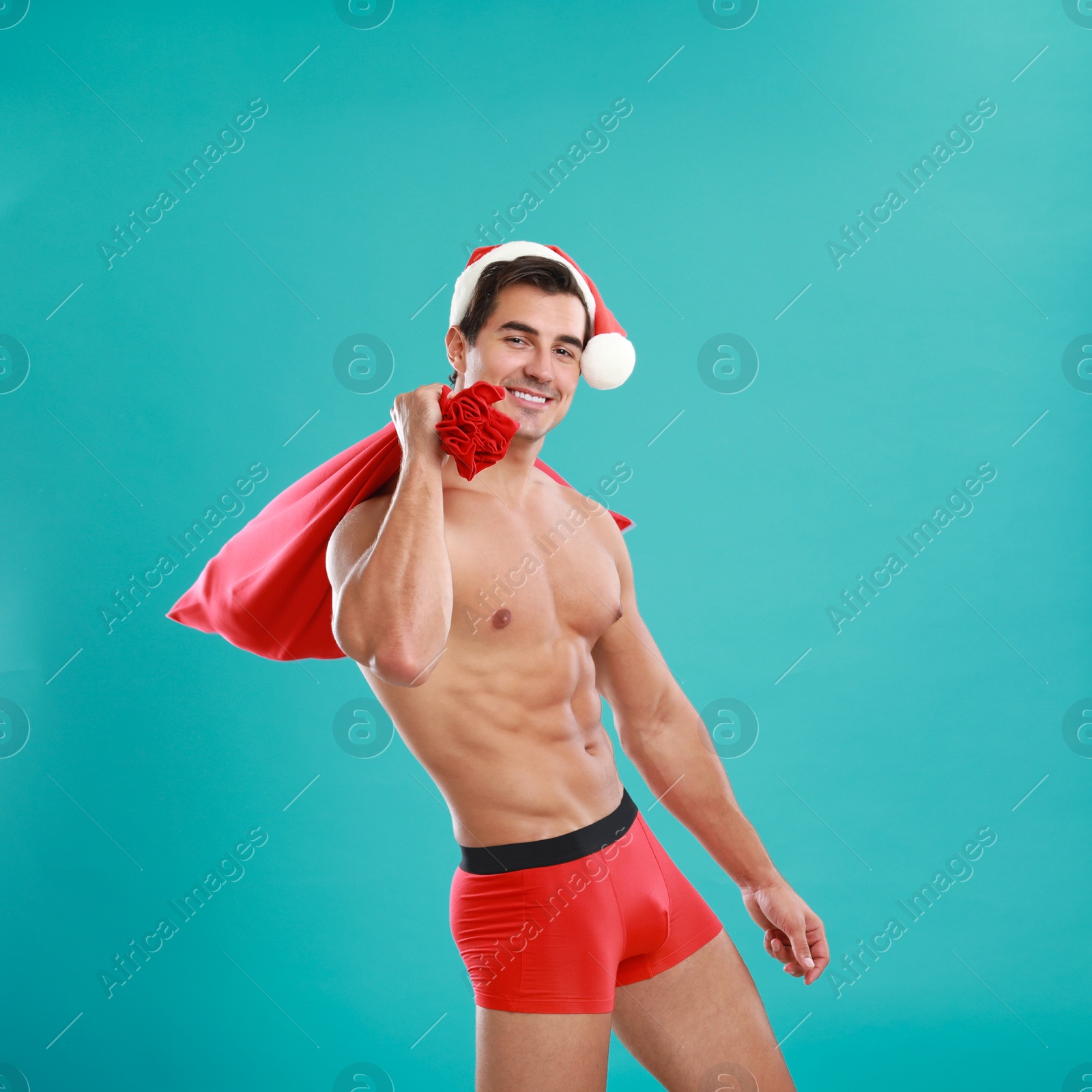 Photo of Sexy shirtless Santa Claus on blue background