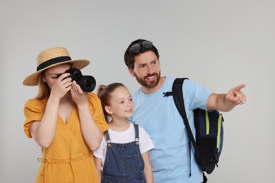 Happy family making photo on light grey background