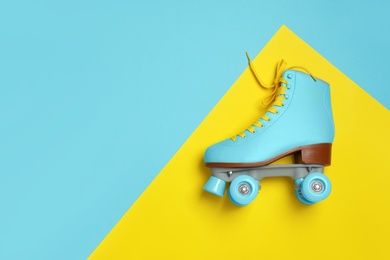 Stylish quad roller skate on color background, top view