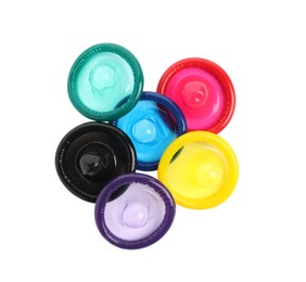 Photo of Unpacked colorful condoms on white background, top view. Safe sex