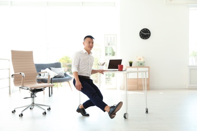 Photo of Young businessman doing exercises in office. Workplace fitness