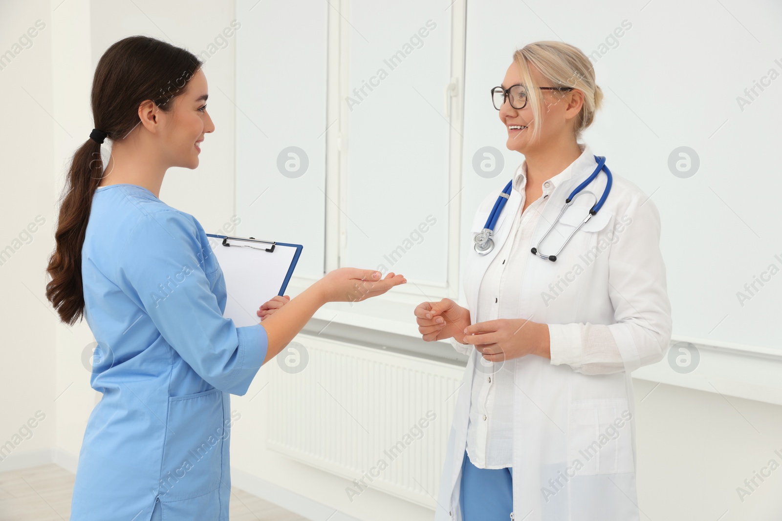 Photo of Medical doctors in uniforms having discussion indoors