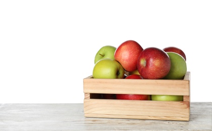 Photo of Wooden crate full of fresh juicy apples on table against white background