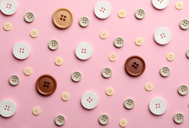 Different sewing buttons on pink background, flat lay