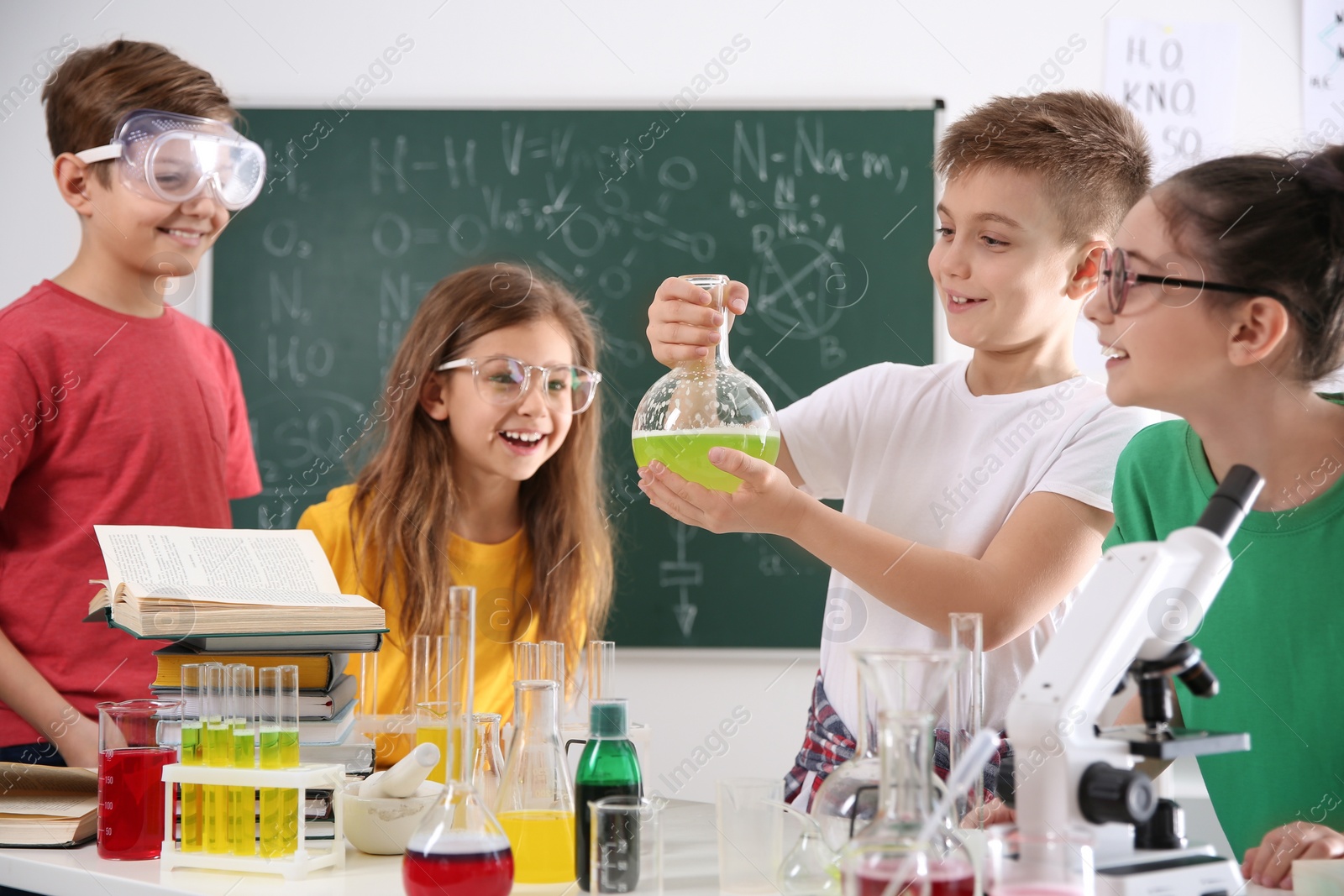 Photo of Smart pupils making experiment in chemistry class