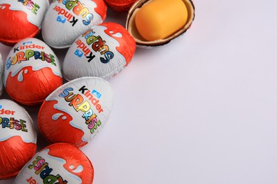 Photo of Sveti Vlas, Bulgaria - June 26, 2023: Kinder Surprise Eggs and plastic capsule with toy on white background, closeup. Space for text
