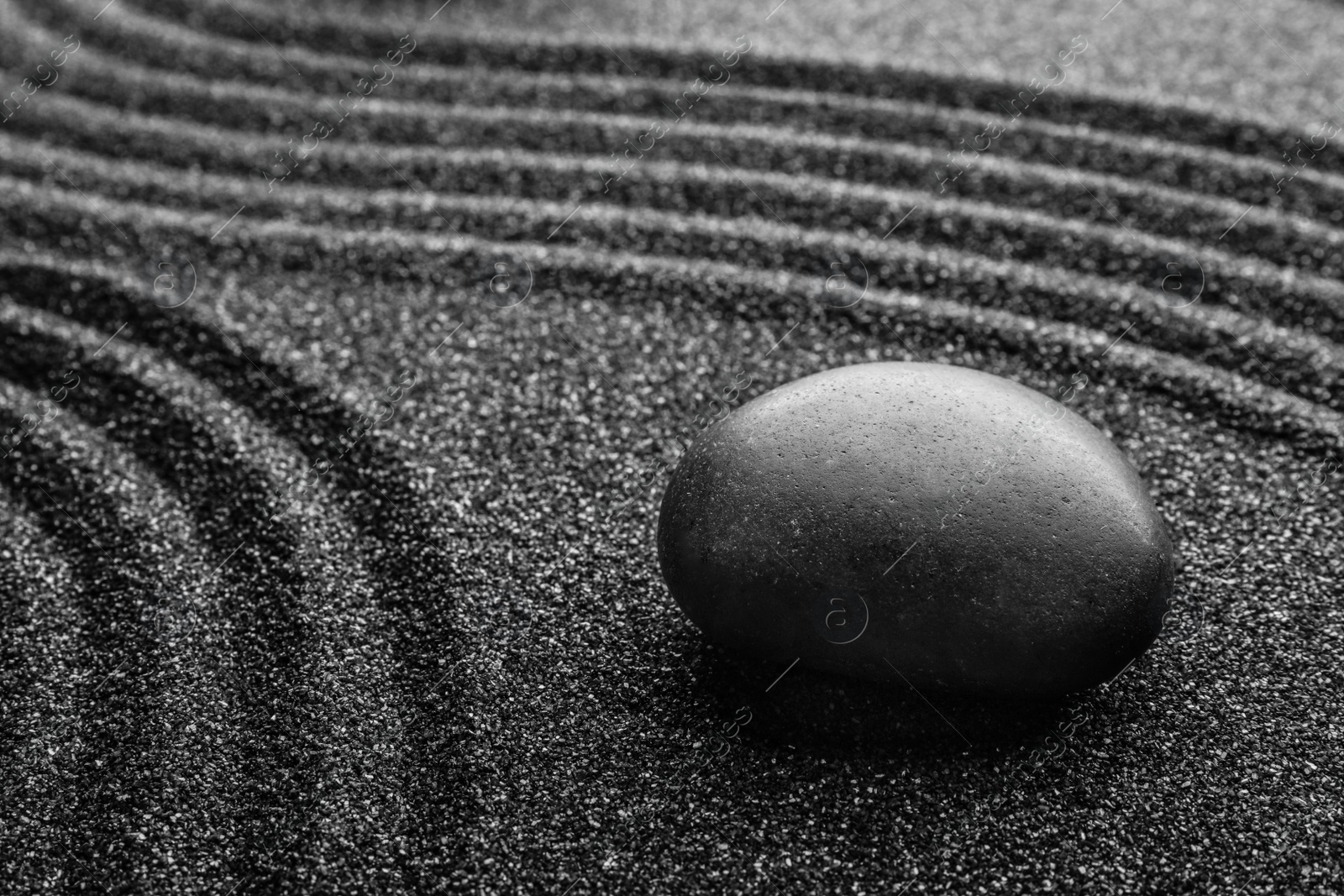 Photo of Black sand with stone and beautiful pattern. Zen concept