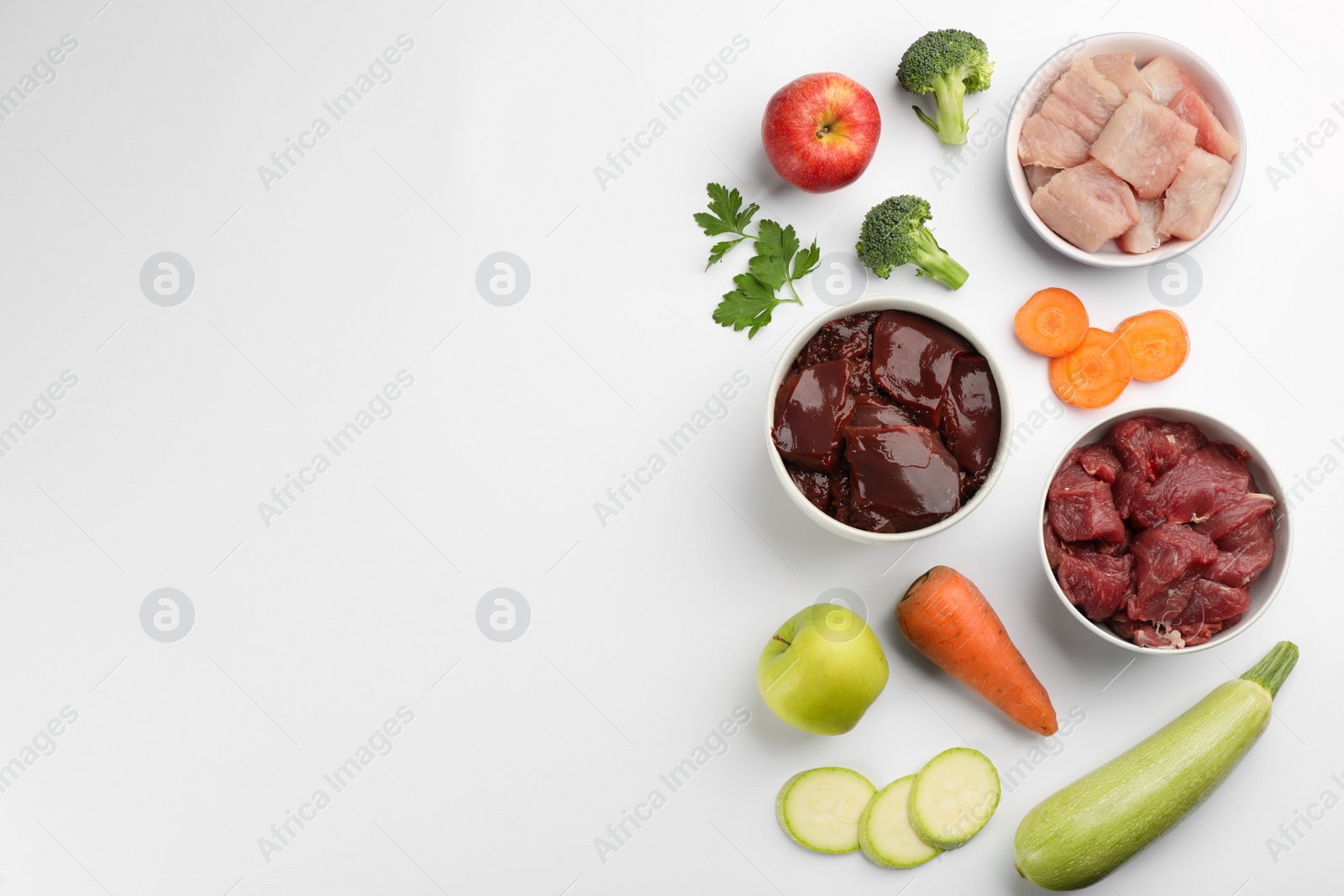 Photo of Pet food and natural ingredients on white background, top view