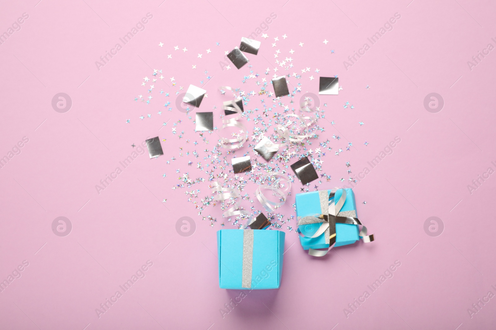 Photo of Flat lay composition with shiny confetti and box on pink background