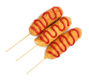 Photo of Delicious deep fried corn dogs with ketchup on white background, top view