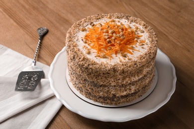 Sweet carrot cake with delicious cream on wooden table