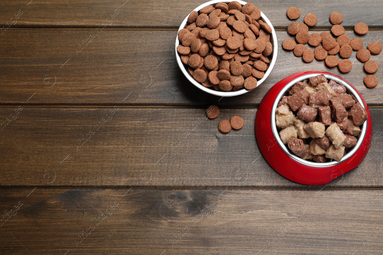 Photo of Wet and dry pet food on wooden table, flat lay. Space for text