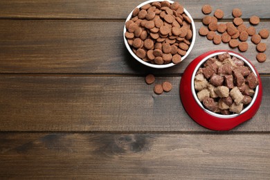 Photo of Wet and dry pet food on wooden table, flat lay. Space for text