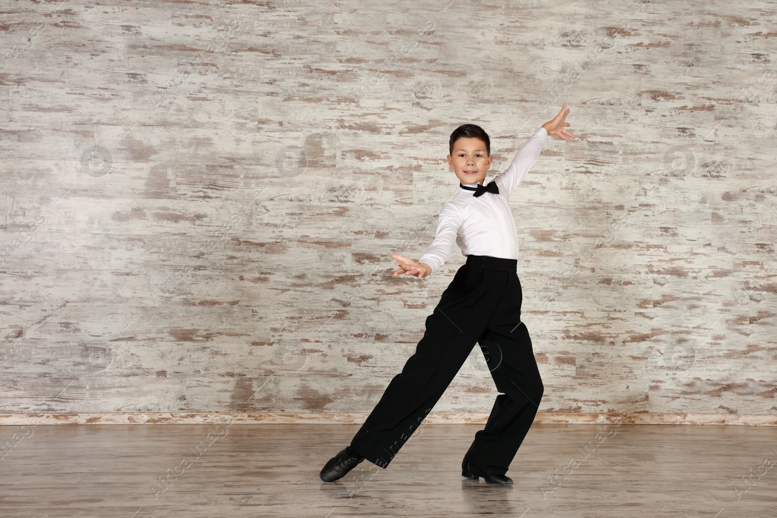 Photo of Adorable little boy dancing in studio, space for text