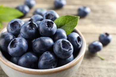 Photo of Bowl of fresh tasty blueberries on table, closeup. Space for text