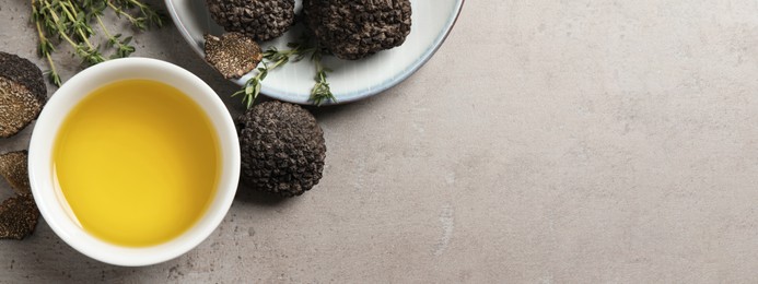 Image of Fresh truffles, oil in bowl and thyme on light grey table, flat lay with space for text. Banner design
