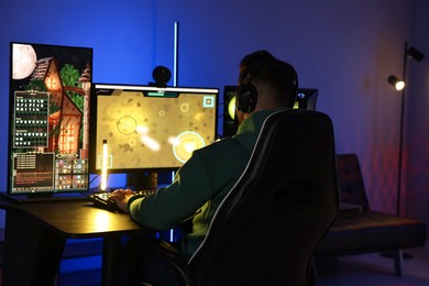 Man playing video games on computer at table indoors