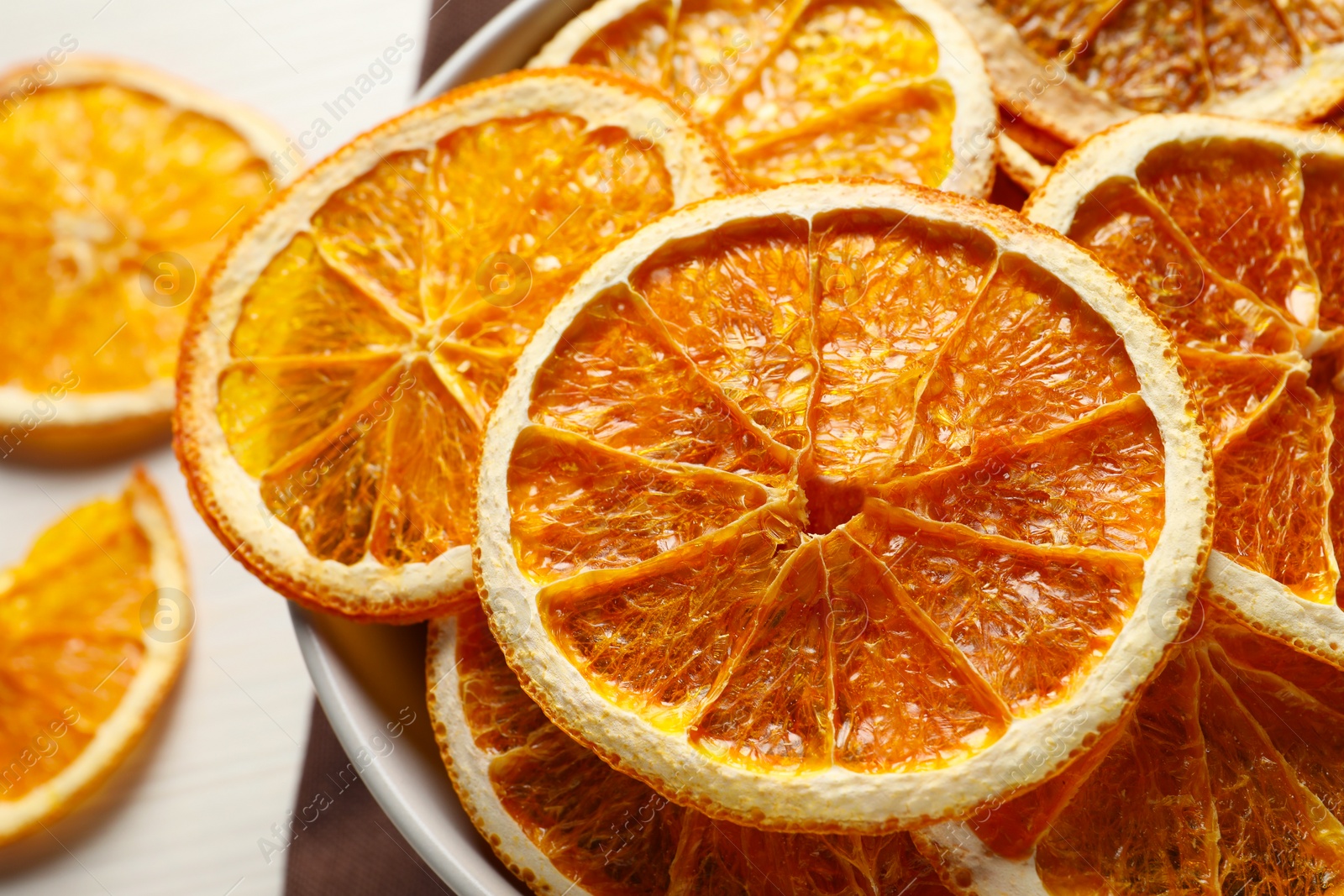 Photo of Many dry orange slices on white wooden table, closeup