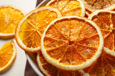 Photo of Many dry orange slices on white wooden table, closeup