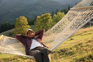 Man resting in hammock outdoors on sunny day