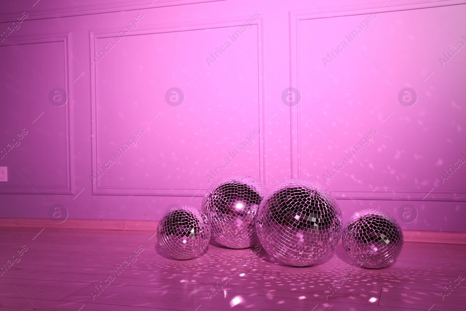 Photo of Shiny disco balls indoors, toned in pink. Space for text