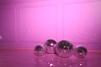 Shiny disco balls indoors, toned in pink. Space for text