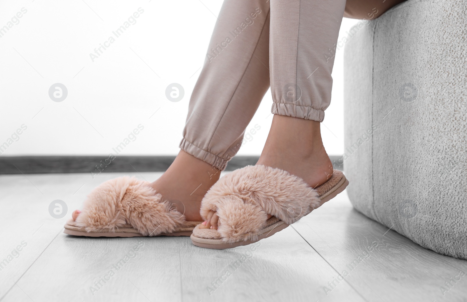 Photo of Woman wearing beige soft slippers at home, closeup