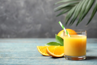 Glass of orange juice and fresh fruits on wooden table. Space for text