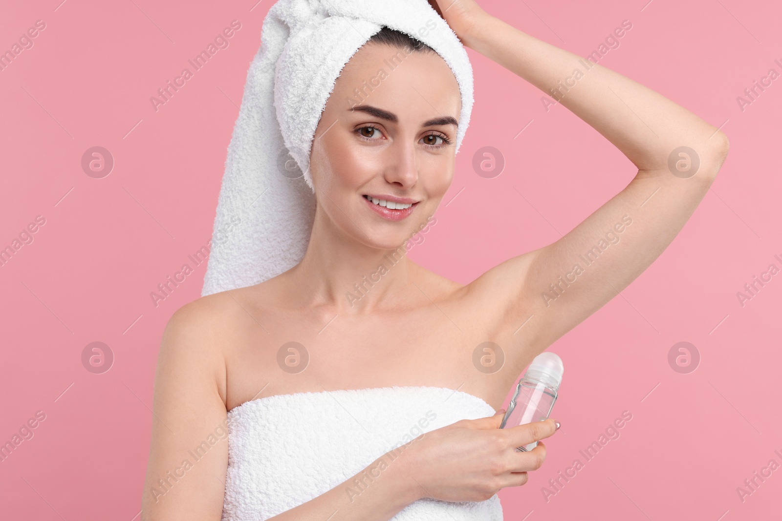 Photo of Beautiful woman applying deodorant on pink background