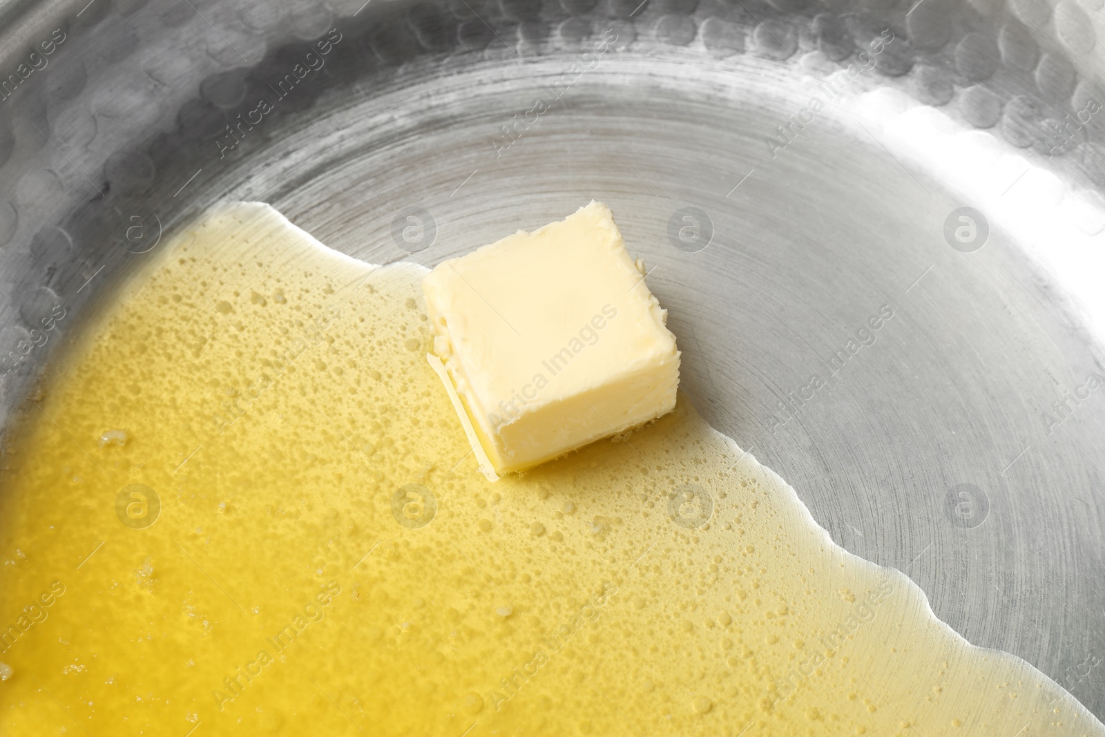 Photo of Frying pan with piece of melting butter, closeup