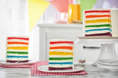 Photo of Delicious rainbow cake for party on table