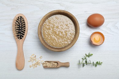 Photo of Homemade hair mask in bowl, ingredients and brush on white wooden table, flat lay