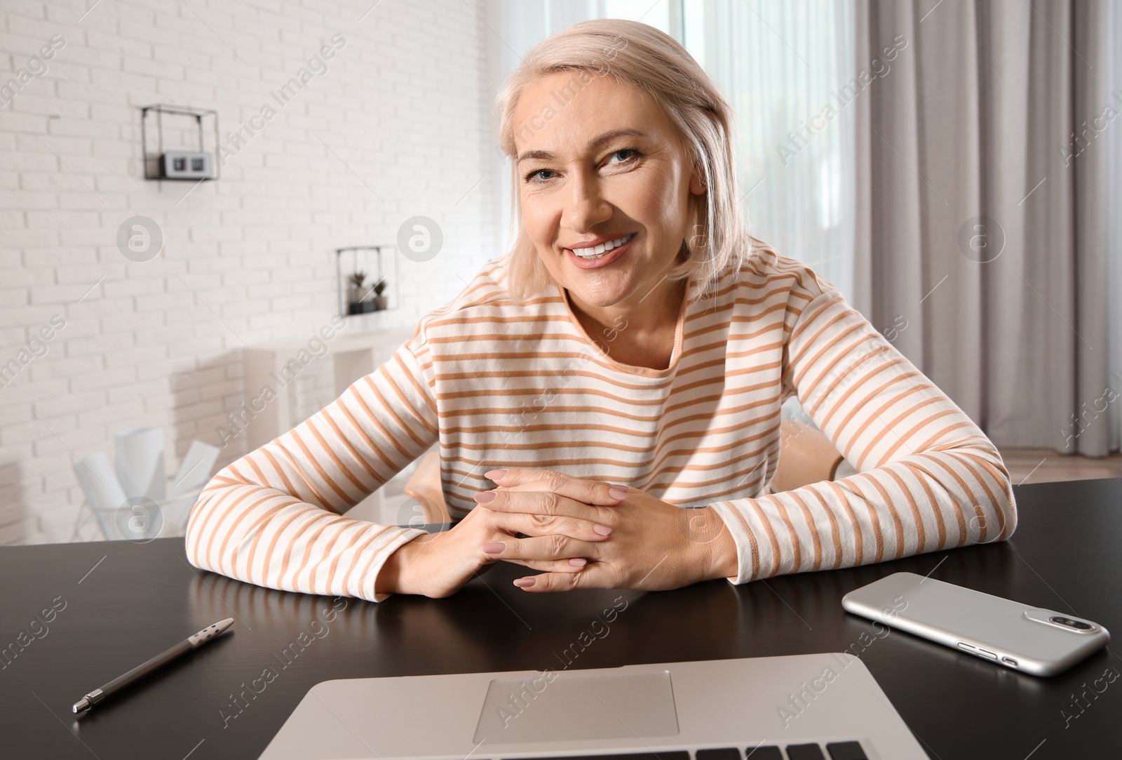 Photo of Mature woman using video chat on laptop at home, view from web camera