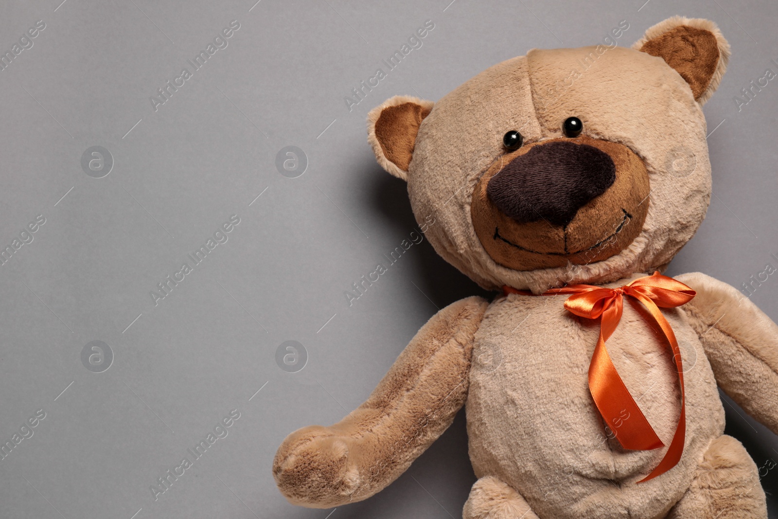 Photo of Cute teddy bear on gray background, top view. Space for text