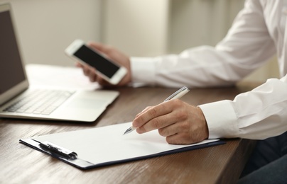 Business trainer working at table in office, closeup