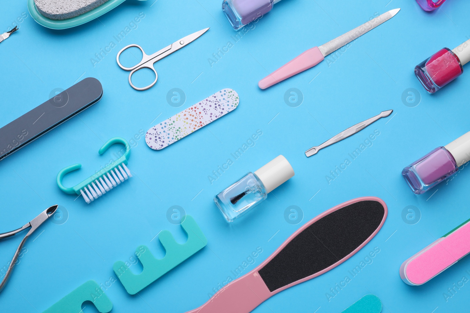 Photo of Set of pedicure tools on light blue background, flat lay