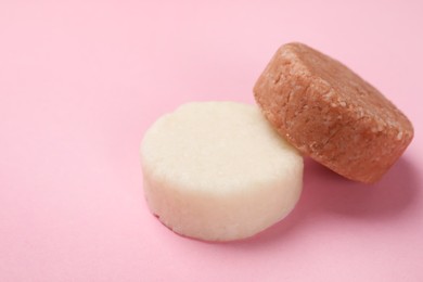 Solid shampoo bars on pink background, closeup. Space for text