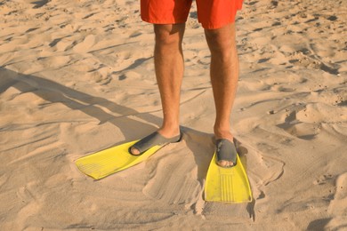 Man in flippers on sand, closeup view