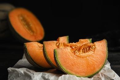 Slices of ripe cantaloupe melon on dark table