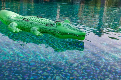 Float in shape of crocodile in swimming pool outdoors