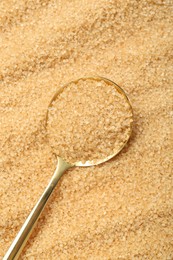 Spoon on granulated brown sugar, top view