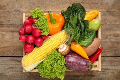 Photo of Different fresh vegetables on wooden table, top view