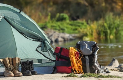 Photo of Set of equipment near camping tent outdoors