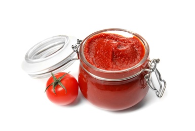 Tasty homemade tomato sauce in glass jar and fresh vegetable on white background