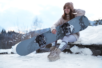 Photo of Young snowboarder wearing winter sport clothes outdoors