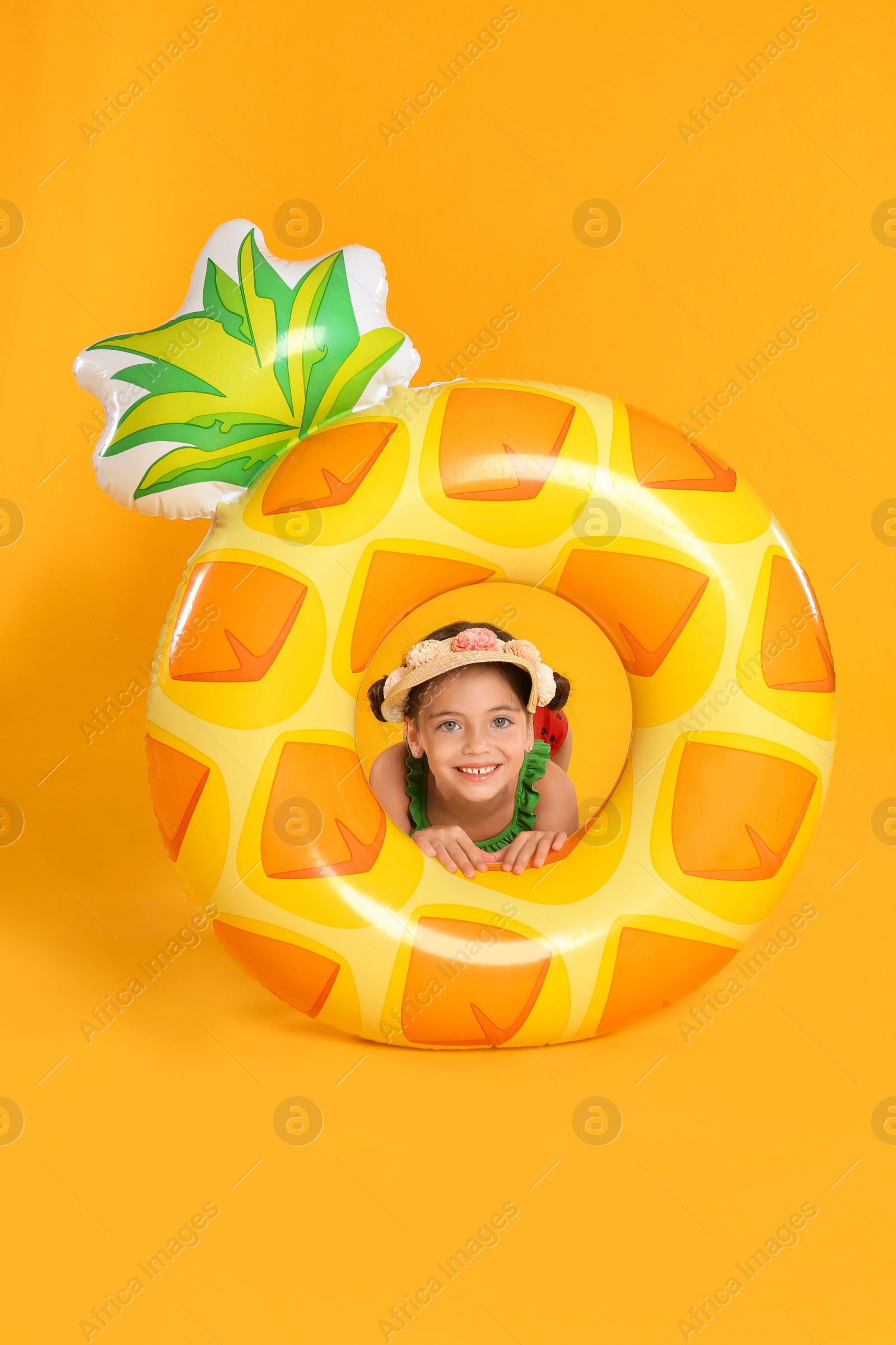 Photo of Cute little child with bright inflatable ring on yellow background. Beach holiday
